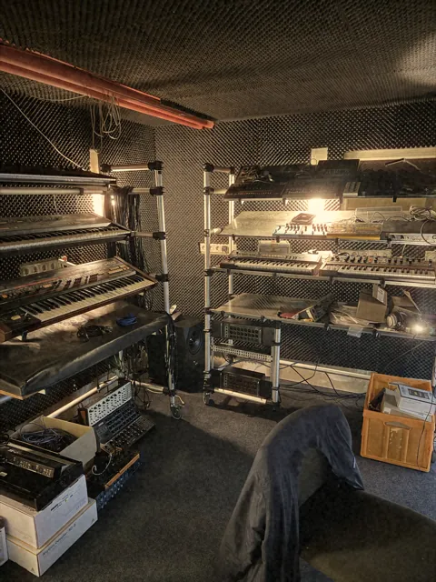 Second Flush studio with shelves full of synthesizers and keyboards